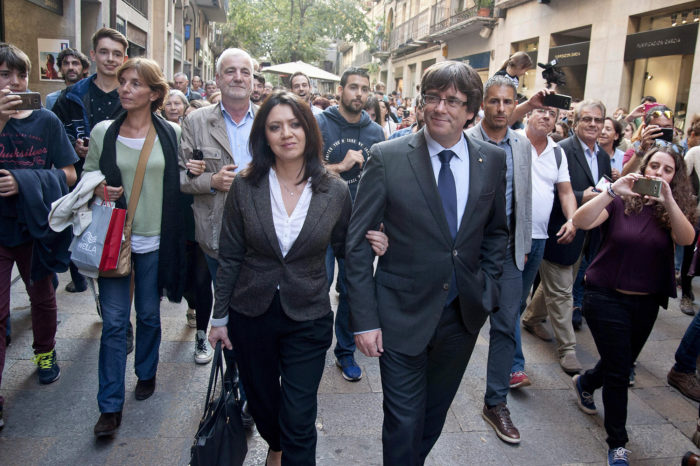 Girona, 2017. október 28. Carles Puigdemont leváltott katalán elnököt (k, jobbra) és feleségét, Marcela Toport kísérik támogatók Gironában 2017. október 28-án, egy nappal az után, hogy Mariano Rajoy spanyol miniszterelnök menesztette őt a spanyol szenátustól kapott felhatalmazás alapján. Puigdemont televíziós nyilatkozatában „demokratikus ellenállásra" szólított fel a spanyol alkotmány 155-ös cikkének alkalmazásával szemben. A spanyol kormány megkezdte a katalán kormányzati feladatok átvételét, a katalán elnöki jogkörök gyakorlásával Soraya Sáenz de Santamaría spanyol miniszterelnök-helyettest bízta meg Rajoy. (MTI/EPA/Robin Townsend)