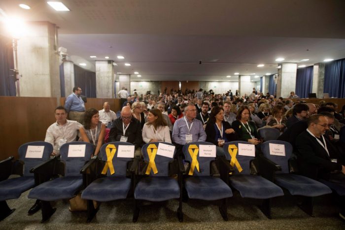 Barcelona, 2017. november 5. Az európai elfogatóparancs alatt álló Antoni Comin, Lluis Puig, Meritxell Serret és Clara Ponsati volt katalán kormánytagok üres helyét jelképező sárga szalagok a függetlenségpárti Európai Katalán Demokrata Párt (PDeCAT) ülésén Barcelonában 2017. november 5-én. Ezen a napon a Spanyolországban lázadással, zendüléssel és hűtlen kezeléssel vádolt Carles Puigdemont menesztett katalán elnök feladta magát a belga rendőrségen. (MTI/EPA/Marta Pérez)