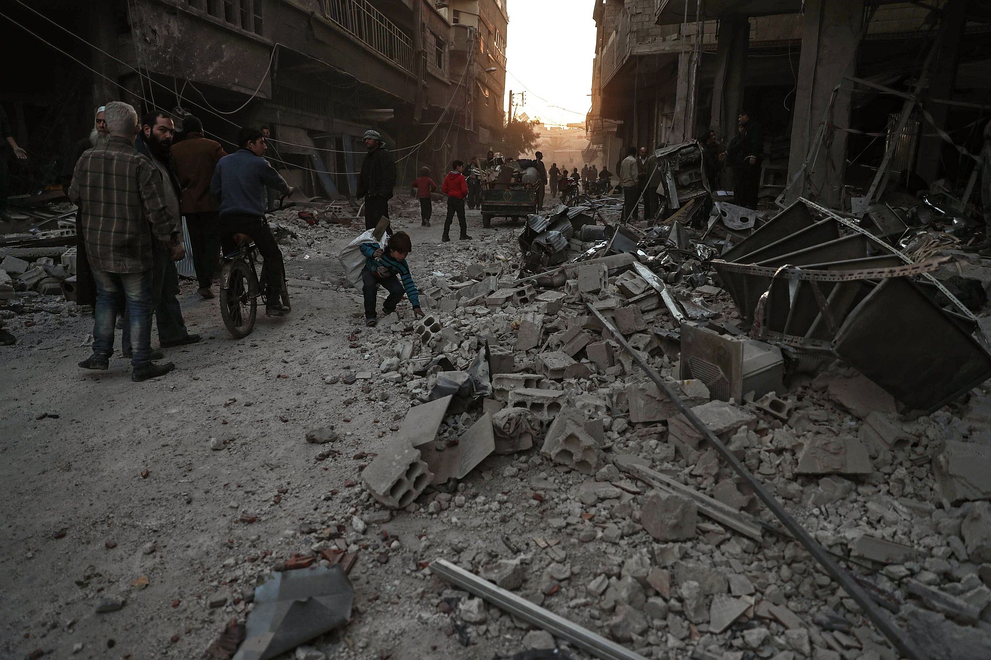 A pusztítás nyomait nézik emberek a szíriai főváros, Damaszkusz Hamoria nevű külvárosában 2017. december 3-án, a szíriai kormánnyal szövetséges erők újabb légicsapása után. A bombázásban legkevesebb 17 ember életét vesztette. (MTI/EPA/Mohamed Badra)
