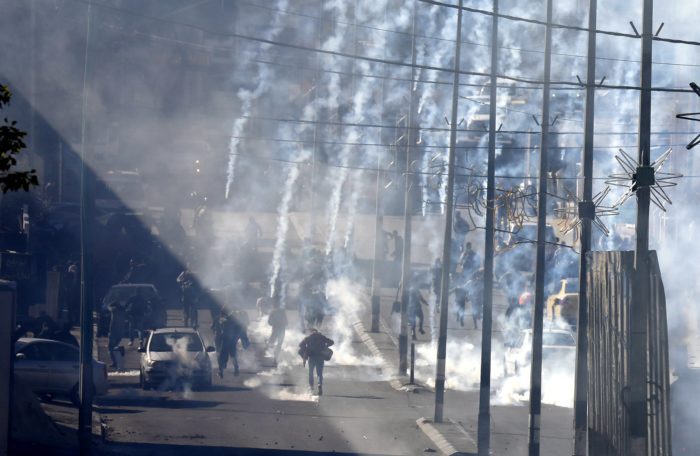 Palesztin tüntetők menekülnek az izraeli rendőrök által feléjük lőtt könnygázgránátok elől a ciszjordániai Betlehemben vívott összecsapásuk közben 2017. december 9-én. Három nappal korábban Donald Trump amerikai elnök bejelentette, hogy az Egyesült Államok Tel-Aviv helyett Jeruzsálemet tekinti Izrael fővárosának. Trump bejelentésére számos muszlim ország felháborodottan reagált, a Hamász palesztin mozgalom, amely a Gázai övezetet uralja, egyenesen felkelésre (intifádára) szólított fel. (MTI/EPA/Abed al-Haslamun)