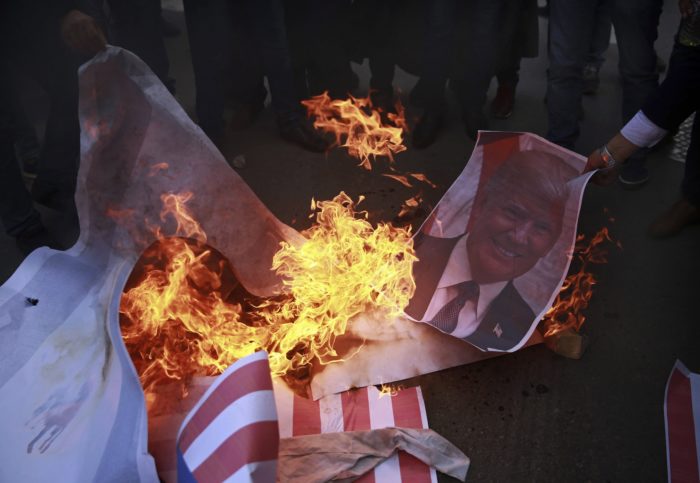 Gáza, 2017. december 7. Donald Trump amerikai elnököt ábrázoló plakátot égetnek palesztinok Gázában 2017. december 7-én, egy nappal azután, hogy Trump aláírta a Jeruzsálemet Izrael fővárosaként elismerő dekrétumot. Trump bejelentette továbbá, hogy Tel-Avivból Jeruzsálembe helyezteti át az amerikai nagykövetséget. (MTI/AP/Halil Hamra)