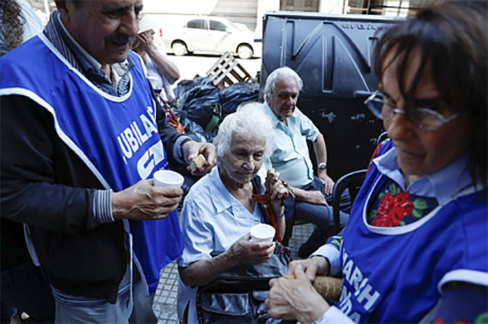 epa06400616 A group of retirees make a toast with bread and water in front of the headquarters of the Congress in Buenos Aires, Argentina, on 20 December 2017, in rejection of the recently approved pension reform. EPA/David Fernández