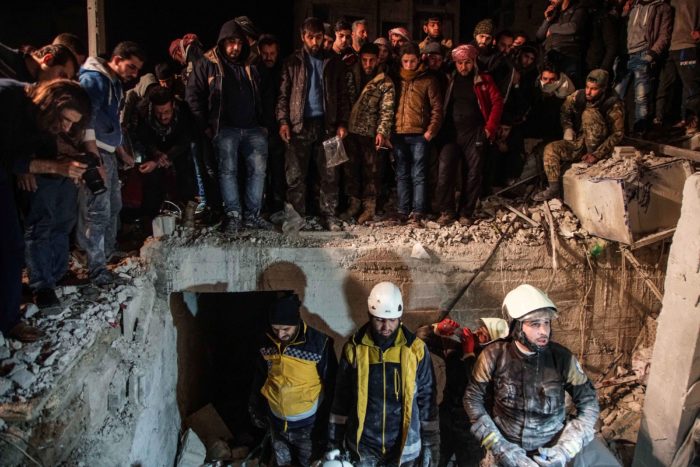 Idlíb, 2018. január 8. Civilek nézik, amint a mentőegységek tagjai túlélők után kutatnak a romok közt a szíriai ellenzék kezén lévő legnagyobb városban, Idlíbben 2018. január 8-án, miután autóba rejtett pokolgép robbant a csecsenek vezette Adzsnad al-Kavkaz (Kaukázus katonái) iszlamista csoport főhadiszállása közelében. A támadásban legkevesebb tizennyolcan életüket vesztették, több tucatnyian megsebesültek. (MTI/EPA/Jahja Nemah)