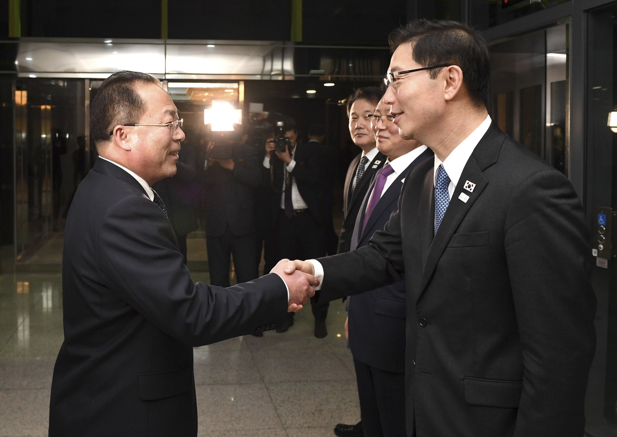 A dél-koreai egyesítési minisztérium által közreadott képen Csun He Szung dél-koreai egyesítési miniszter-helyettes (j) és Dzson Dzsong Szu, az észak-koreai delegáció vezetője kezet fog a februári dél-koreai téli olimpián való észak-koreai részvételről tartott tárgyalás következő fordulója után a két Koreát elválasztó panmindzsoni demilitarizált övezet dél-koreai oldalán 2018. január 17-én. A felek megállapodtak abban, hogy Phenjan sportolókat, magas rangú tisztviselőket és szurkolókat küld a téli olimpiára. (MTI/AP/Dél-koreai egyesítési minisztérium)