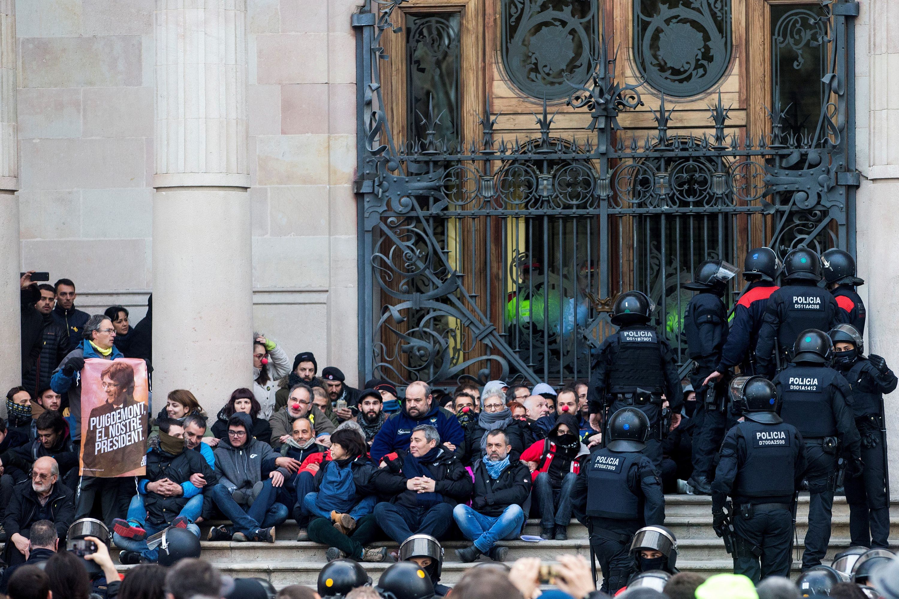 Barcelona, 2018. február 23. Katalán rendőrök érkeznek Carles Puigdemont leváltott katalán elnök támogatóinak a bebörtönzött függetlenségpárti katalán politikusok szabadon bocsátását követelő ülőtüntetésére a katalán legfelsőbb bíróság (TSJC) barcelonai épületénél 2018. február 23-án. (MTI/EPA/Quique García)