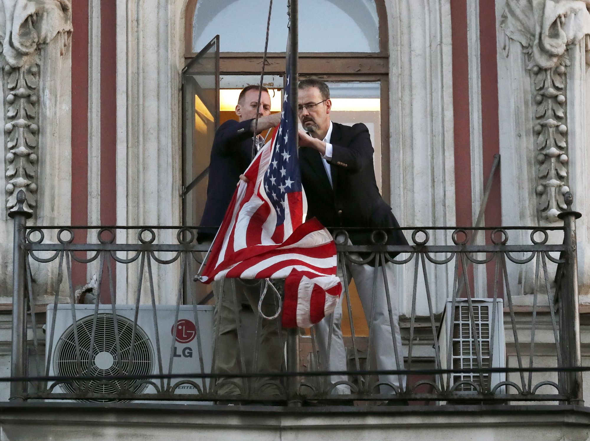 A szentpétervári amerikai konzulátus munkatársai leveszik az amerikai zászlót 2018. március 31-én. Az amerikai szankciókra válaszul Oroszország 60 amerikai diplomatát utasított ki és a szentpétervári konzulátus bezárásáról döntött. Az orosz hatóságok két napot adtak az épület teljes kiürítésére. EPA/ANATOLY MALTSEV