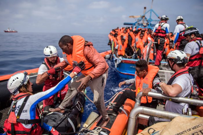 Földközi-tenger, 2018. április 21. Afrikai migránsnak segítenek gumicsónakba szállni az illegális bevándorlók tengeri mentését végzõ SOS Mediterranee civil szervezet Aquarius nevû hajója legénységének tagjai a Földközi-tengeren 2018. április 21-én. Az Aquarius mintegy 250 csónakban utazó illegális bevándorlót vett a fedélzetére a líbiai partoktól mintegy 50 kilométerre. (MTI/EPA/Christophe Petit Tesson)