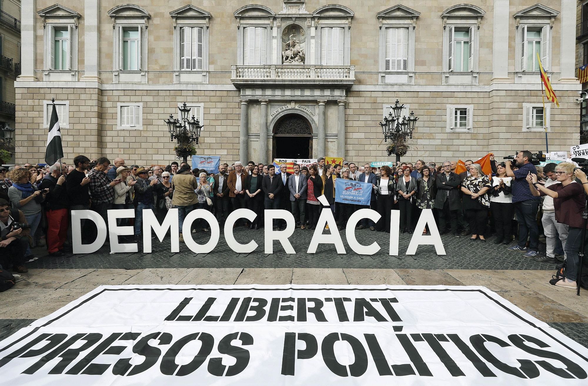 Barcelona, 2017. november 2. "Demokráciát" és "Szabadságot a politikai foglyoknak" felirattal tüntetnek a leváltott katalán kormány támogatói a barcelonai kormányhivatal előtt 2017. november 2-án, amikor a menesztett elnökségi tagok bírósági meghallgatásra utaztak Madridba. Két nappal korábban José Manuel Maza spanyol állami főügyész büntetõeljárást kezdeményezett a feloszlatott katalán kormány, valamint a katalán parlament elnökségének tagjai ellen lázadás, zendülés, hűtlen kezelés és egyéb bűncselekmények miatt. (MTI/EPA/Javier Etxezarreta)
