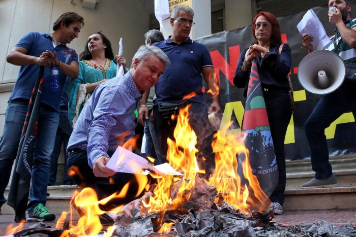 epa06247965 Medical personnel burn their degrees as a symbolic act to oppose the Greek government's reforms and austerity measures in the public health sector, outside the Greek Health Ministry, in Athens, Greece, 06 October 2017. EPA/ORESTIS PANAGIOTOU