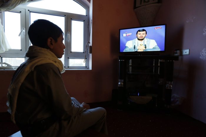 Szanaa, 2017. december 19. Abdel-Malik al-Húszi, a jemeni síita húszi lázadók parancsnoka televíziós beszédét nézi egy jemeni fiú a fővárosban, Szanaában 2017. december 19-én, miután a szaúdi vezetésű arab koalíció erői elfogták a lázadók egyik rakétáját, amelyet a rijádi királyi palotára irányítottak. (MTI/EPA/Jahja Arhab)