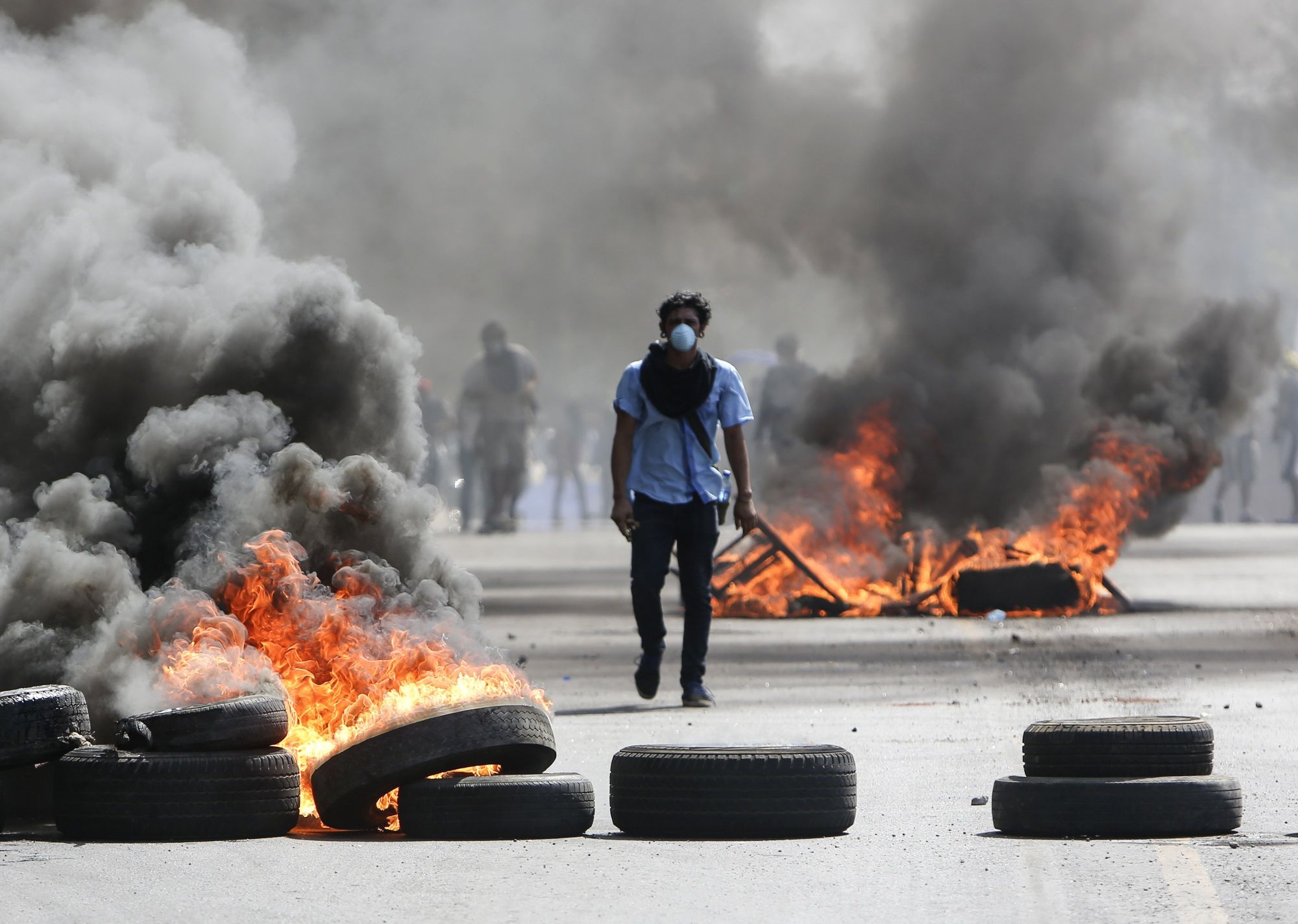 Tüntető égő gumiabroncsok között a rohamrendőrökkel vívott összecsapás közben a nicaraguai főváros, Managua egyik főutcáján 2018. április 20-án.  (MTI/AP/Alfredo Zuniga)